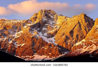 A mountain peak in the rays of the setting sun. Mountain peak snow in evening light. Mountain peak at sunset. Mountain scene