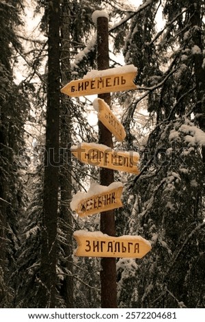 mountain peak sign on the Great Ural Trail on a winter day. Text in Russian: Iremel, bakty, zigalga, zherebchik