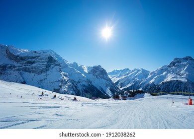 Mountain peaks and clean empty ski trails in Pralognan-la-Vanoise range over snowy tops in French Alps