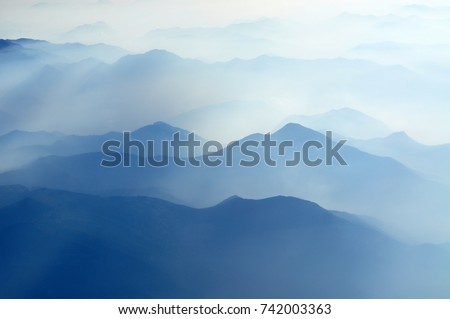 mountain peaks in morning fog - foggy morning over Italian mountains near Milan 
