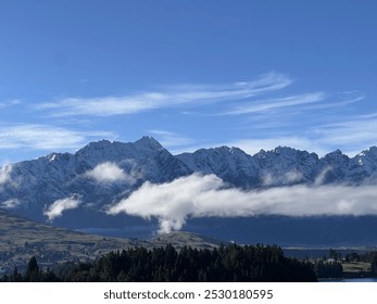 Mountain Range with Clouds and Trees Under a Blue Sky