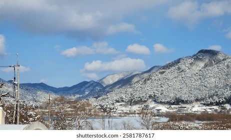 A mountain range covered in snow with a small village at the foot.