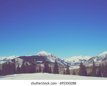 Mountain range during winter on the slopes during vacation.  Shows active lifestyle from snowboarding perspective.