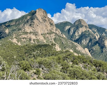 a mountain range with a few trees and a few clouds