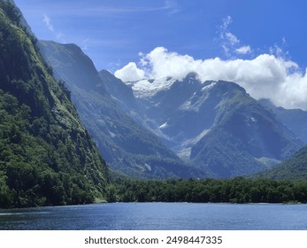 Mountain Range from Ocean View, snow capped mountain range, blue water and blue sky, bright, sunny, vibrant green plant covered mountains, beautiful natural landscape, scenic outdoors - Powered by Shutterstock