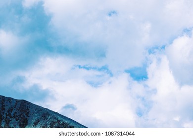 Mountain range under the clouds, rocky peaks and hills under a blue sky