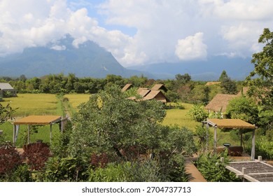 A mountain range is visible in the background. There are several small houses in the foreground