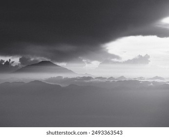 A mountain range is visible in the distance with a dark cloud in the sky. The sky is overcast and the clouds are low, giving the image a moody and somber feel - Powered by Shutterstock