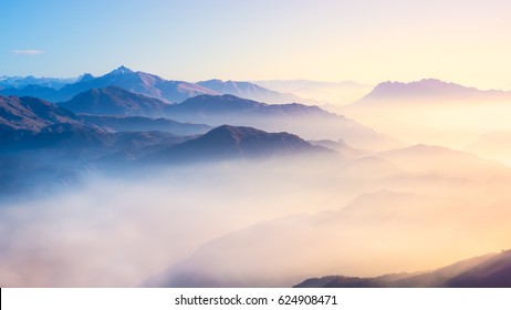 Mountain range with visible silhouettes through the morning colorful fog. - Shutterstock ID 624908471