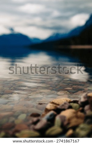 mountain reflection in Lake McDonald Glacier National Park in Montana with colorful rocks