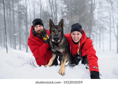 Mountain Rescue Service With Dog On Operation Outdoors In Winter In Forest, Digging Snow.