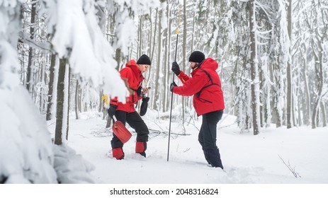 Mountain rescue service on operation outdoors in winter in forest, finding person after avalanche. - Shutterstock ID 2048316824