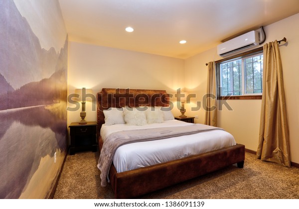 Mountain retreat calming small bedroom with mural in purple tones and white bedding. 