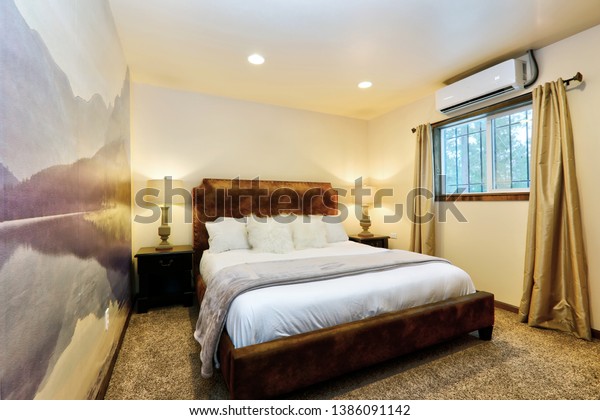 Mountain retreat calming small bedroom with wallpaper mural in purple tones and white bedding. 