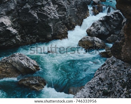 Mountain river with blue water. Wild nature landscape and  grey rocks