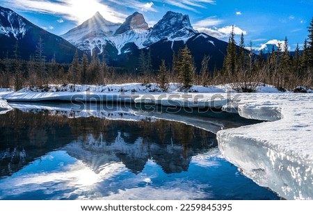 Mountain river in a snowy forest in winter. River water reflection in winter mountains. Snow river in mountains. Winter mountain river in snow