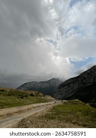 Mountain Road Under Dramatic Cloudy Sky