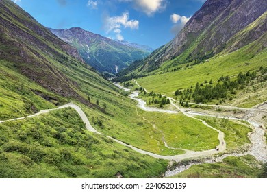 The mountain road winds through a beautiful green valley among the Grossglockner mountains, Alps, Austria