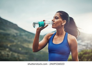 Mountain, runner or woman drinking water on break to hydrate or relax for healthy energy in exercise. Tired, fatigue and thirsty girl athlete with liquid or hydration in marathon training or workout - Powered by Shutterstock