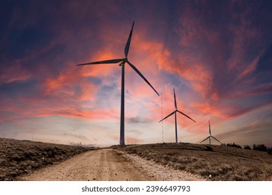 Mountain scenery in winter with snow and a wind farm at sunset. Wind turbines for green economy and technology are the only solution to protect the planet from climate change and global warming  - Powered by Shutterstock