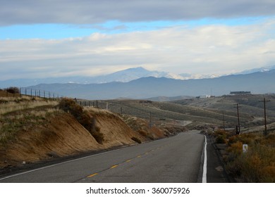 A mountain secondary road navigates the California foothills of the southern Sierra Nevada Range leading to a little snow at the higher elevations.