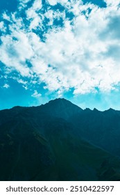 Mountain Silhouette under Dramatic Cloudy Sky
A rugged mountain silhouette is framed against a dramatic cloudy sky, creating a striking contrast of light and shadow in the Kazbegi region.
