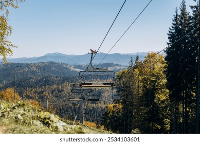 Mountain ski lift on a autumn day over the mountains. Ski lift in the mountains in the sun. Carpathians, Ukraine. - Powered by Shutterstock