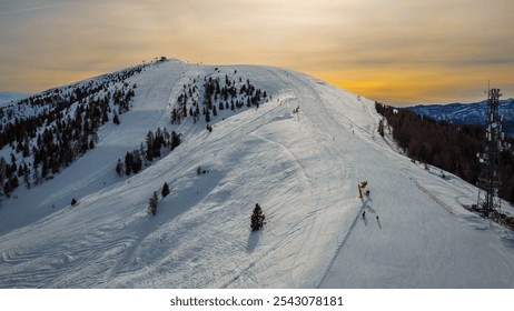 Mountain with skiers on the ski slopes with sunset behind. Ski resort and ski lift in winter at Passo Brocon, Trentino. - Powered by Shutterstock