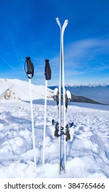 Mountain Skis And Poles Stuck In Snow On A Background Of Mountains