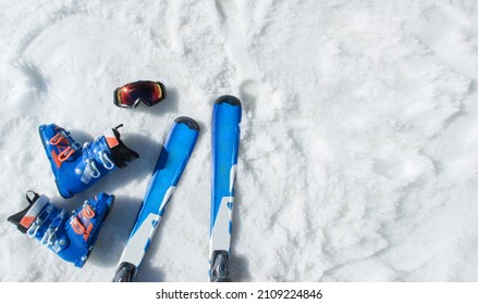 Mountain Skis, Sunscreen Mask, Ski Goggles And Ski Boots On Bright Alpine Snow. Winter Holidays. Vacation, Travel Content. Copy Space