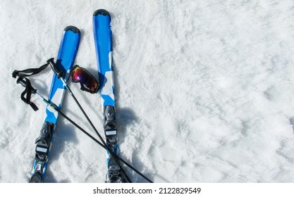 Mountain Skis, Sunscreen Mask And Ski Sticks On Bright Alpine Snow. Winter Holidays. Vacation, Travel Content. Copy Space
