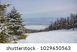 mountain sky slope in winter with green forest and frosted lake in charlevoix quebec canada