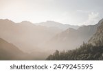 Mountain slopes in haze with rocks covered with forest and vegetation in Tien Shan mountains in Tajikistan in Pamir early in the morning