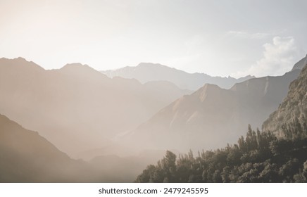 Mountain slopes in haze with rocks covered with forest and vegetation in Tien Shan mountains in Tajikistan in Pamir early in the morning - Powered by Shutterstock