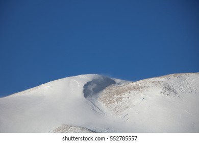 Mountain Snowdrift with blue sky and windblown snowy peaks - Powered by Shutterstock