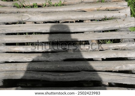 Mountain spring bridge. My shadow on a wooden footpath. 