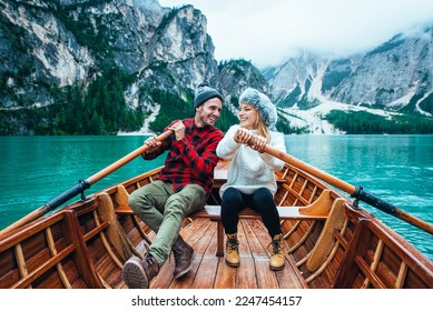Mountain stories. Happy couple on a wanderlust vacation. Boyfriend and girlfriend spending time together at the lake. Storytelling concept about lifestyle and winter travels - Shutterstock ID 2247454157