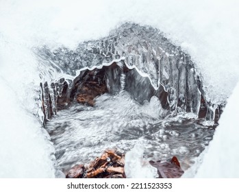 Mountain Stream Flowing Beneath The White Frozen Snow. Close Up Detail.