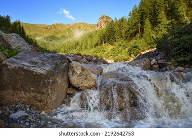 Mountain Stream In The High Mountains. Creek Flowing Over The Rocks. Powerful River Bed In The Alps.