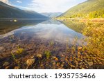 Mountain summer landscape of a beautiful calm idyllic reflection on Kootenay Lake, Nelson BC, Canada.