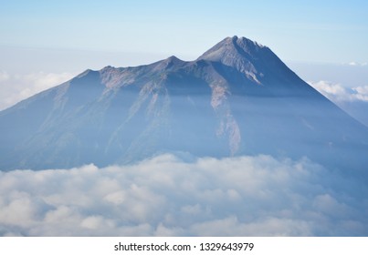 a mountain surrounded by clouds above a height - image