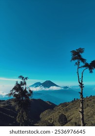 mountain surrounded by clouds in a clear sky