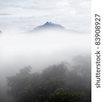 The mountain top of Mount Merapi exposed above a foggy valley on a cool early morning.