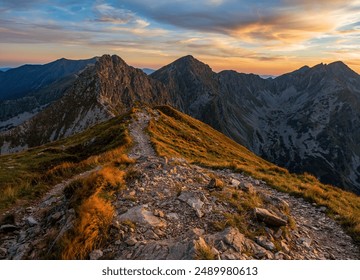 Mountain trail leading along the mountain ridge of beautiful mountains with autumn grass and colorful sky. Western Tatras, High Tatras, Slovakia, Poland. Discovering hiking in a colorful autumn. - Powered by Shutterstock