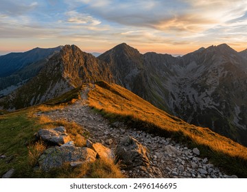 Mountain trail leading along the mountain ridge of beautiful mountains with autumn grass and colorful sky. Western Tatras, High Tatras, Slovakia, Poland. Discovering hiking in a colorful autumn. - Powered by Shutterstock