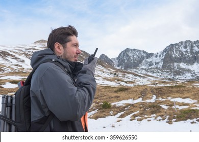 Mountain trekking - European man talking on a walkie-talkie