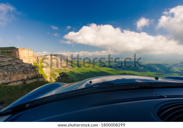 Mountain view from\
the car cockpit with\
clouds