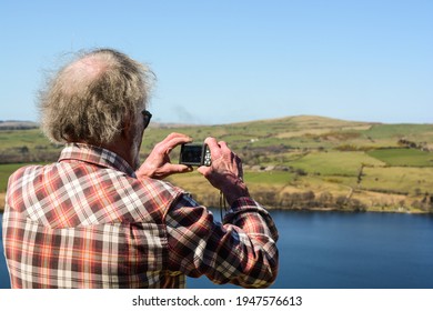 A mountain walker, photographing the view.
