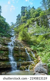 Mountain Waterfall In The Forest, A Large Noisy Stream Of Water, A Wild Natural Spring In A Remote Place.