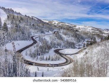 Mountain winter: The winding road to the Deer Valley Ski Resort,  host site of 2002 Winter Olympics, near Park City and The Canyons, a short drive from Salt Lake City, Utah,  with snow covered trees.